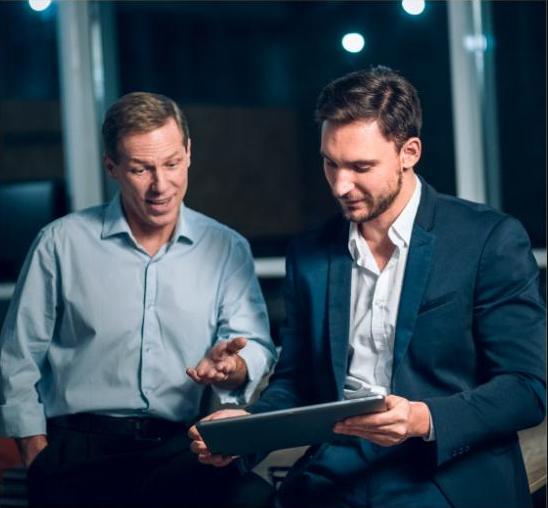 Two colleagues reviewing a tablet together