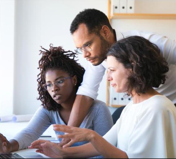Team members collaborating around a laptop